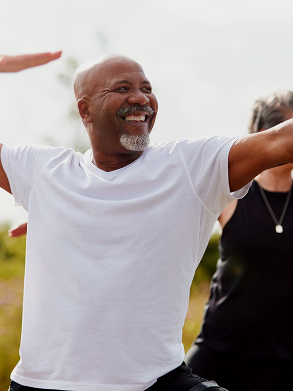 Older man participating in outside yoga.